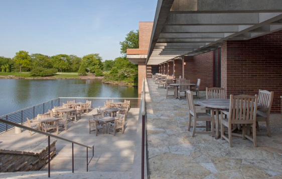 Outdoor dining patio along a lake with tables and chairs